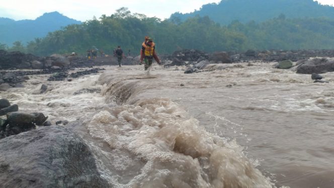 
 Puluhan Anggota TNI Bantu Gendong Siswa Menyeberangi Aliran Banjir Lahar Semeru di Lumajang